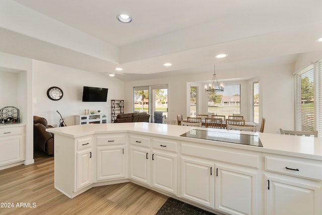 kitchen with white cabinetry, light hardwood / wood-style flooring, hanging light fixtures, and black electric cooktop