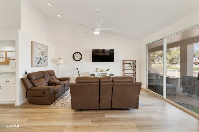 living room with light hardwood / wood-style floors, ceiling fan, and high vaulted ceiling