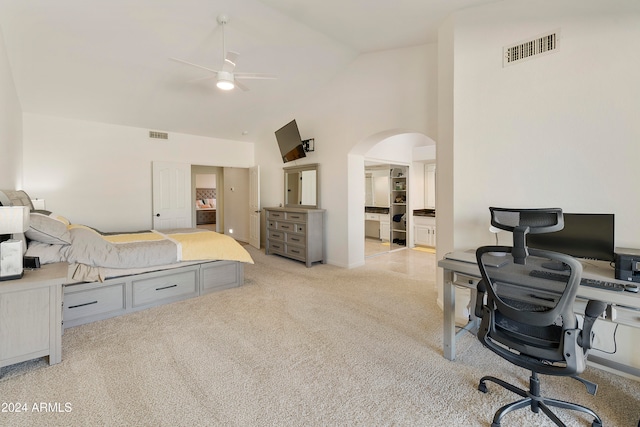 bedroom with high vaulted ceiling, light carpet, ceiling fan, and connected bathroom