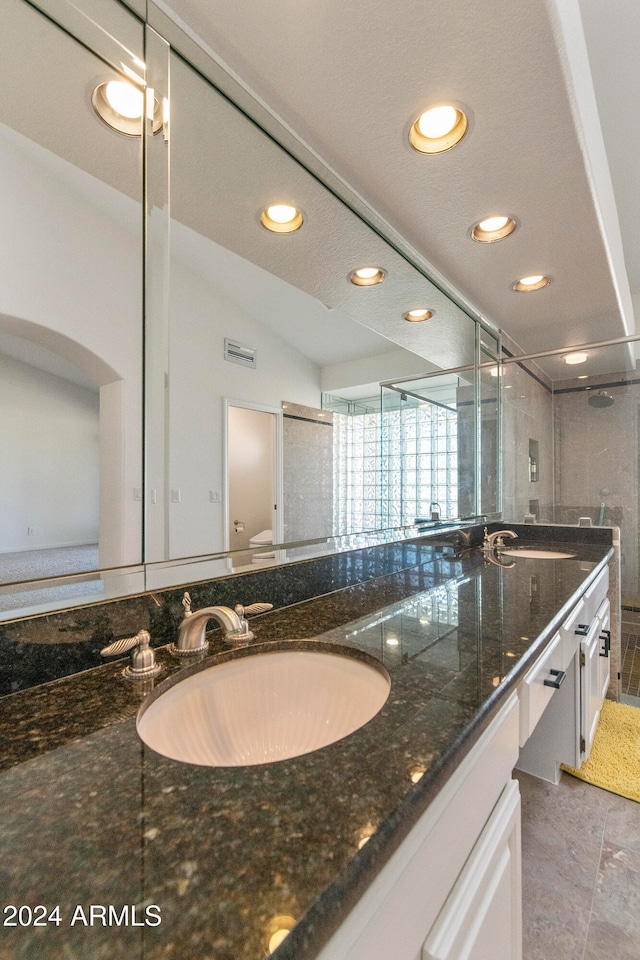 bathroom with vanity, tile patterned flooring, toilet, and lofted ceiling