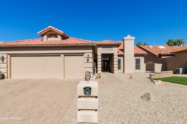 mediterranean / spanish-style house featuring a garage and cooling unit