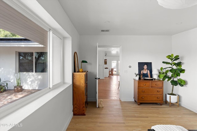 corridor featuring plenty of natural light and light hardwood / wood-style flooring