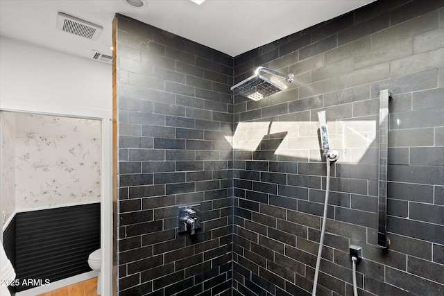 bathroom with tiled shower and toilet