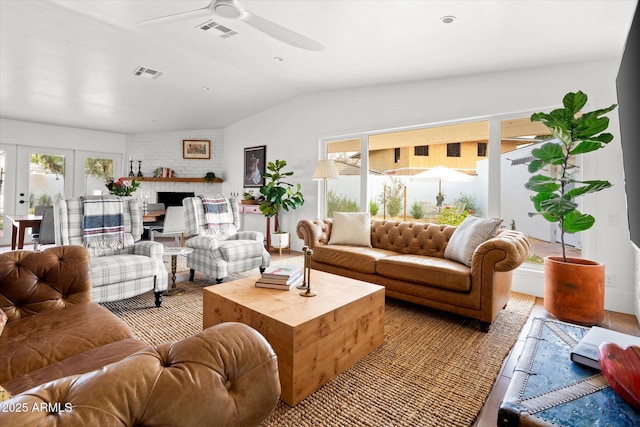 living room featuring french doors, ceiling fan, lofted ceiling, and a fireplace