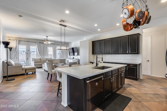 kitchen featuring dishwasher, a center island with sink, a kitchen bar, sink, and french doors