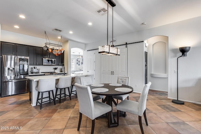 dining space featuring a barn door and sink