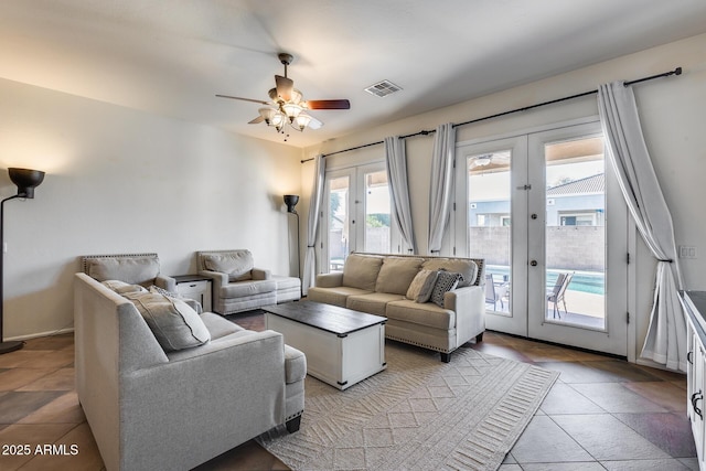 tiled living room with ceiling fan and french doors