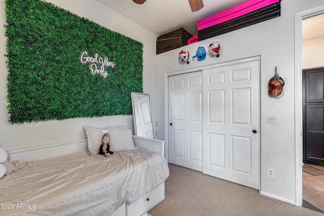 bedroom with ceiling fan, a closet, and light colored carpet