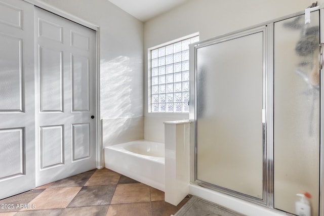 bathroom with independent shower and bath and tile patterned floors