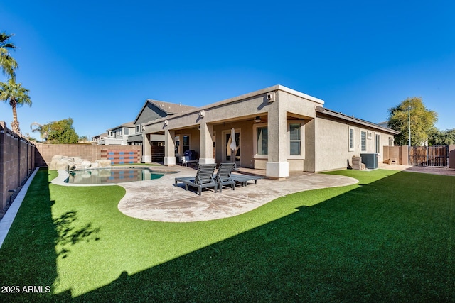 back of house with a lawn, central AC unit, ceiling fan, a patio area, and a fenced in pool