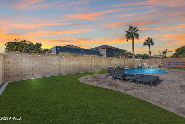 yard at dusk with a patio area and a fenced in pool