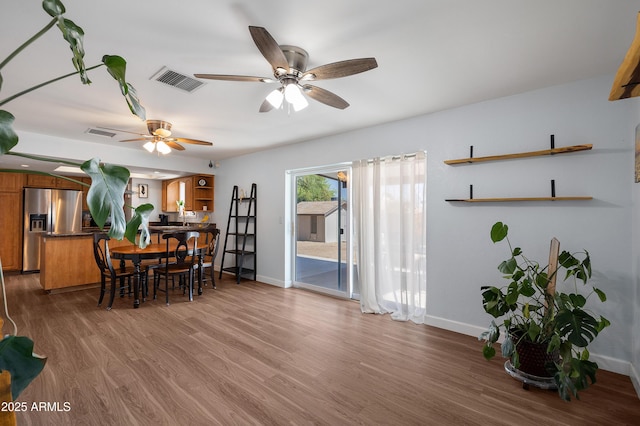 dining area with baseboards, a ceiling fan, and wood finished floors