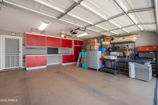 garage with a garage door opener, ceiling fan, and a workshop area