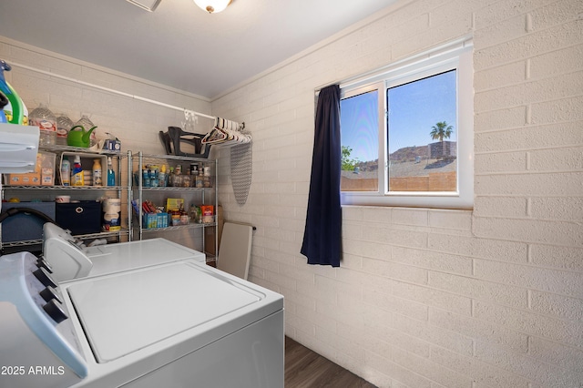 clothes washing area featuring washer and dryer and wood finished floors