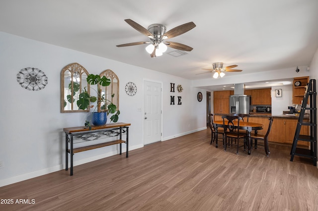 dining space with a ceiling fan, light wood-type flooring, and baseboards