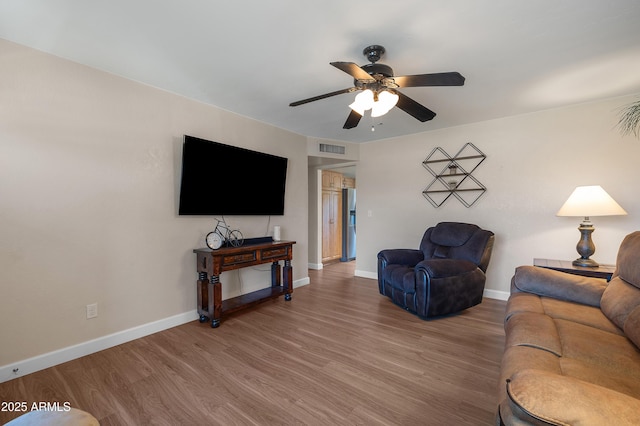 living room with a ceiling fan, wood finished floors, and baseboards