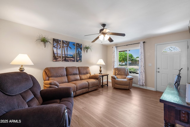 living area featuring a ceiling fan, wood finished floors, and baseboards
