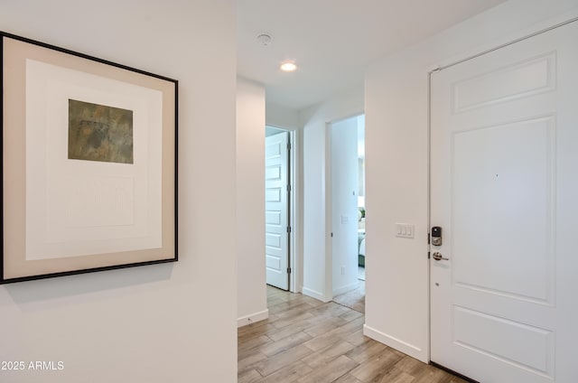 corridor featuring recessed lighting, baseboards, and light wood-type flooring