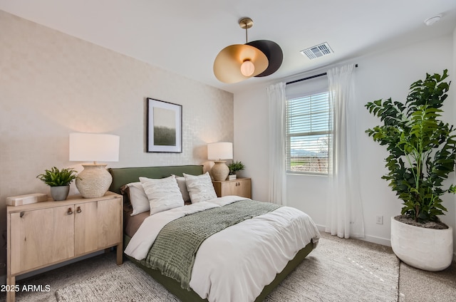 bedroom featuring baseboards, visible vents, and light carpet