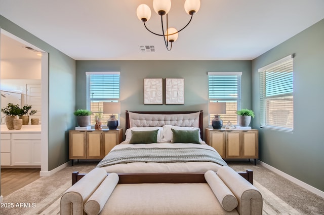 bedroom with visible vents, multiple windows, ensuite bath, and baseboards