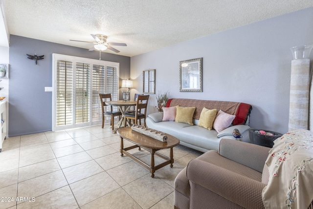 living room featuring a textured ceiling, ceiling fan, and light tile patterned flooring