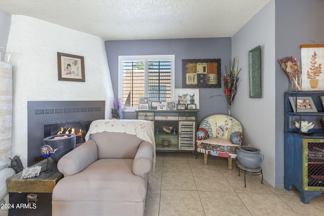 tiled bedroom featuring a textured ceiling and a tiled fireplace