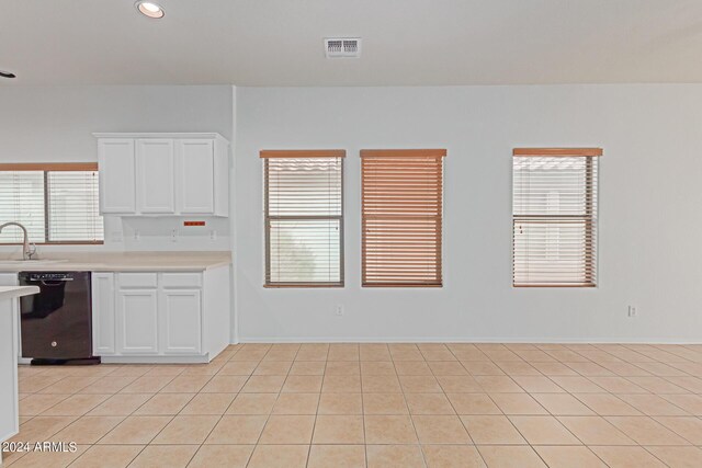 kitchen with black dishwasher, white cabinetry, sink, and light tile patterned floors