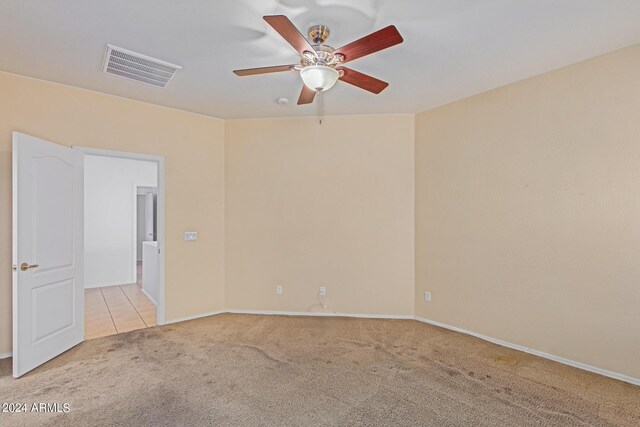 spare room featuring ceiling fan and light colored carpet