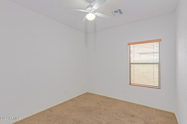 carpeted spare room featuring ceiling fan