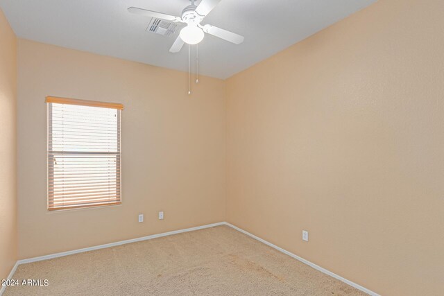 spare room featuring light carpet and ceiling fan