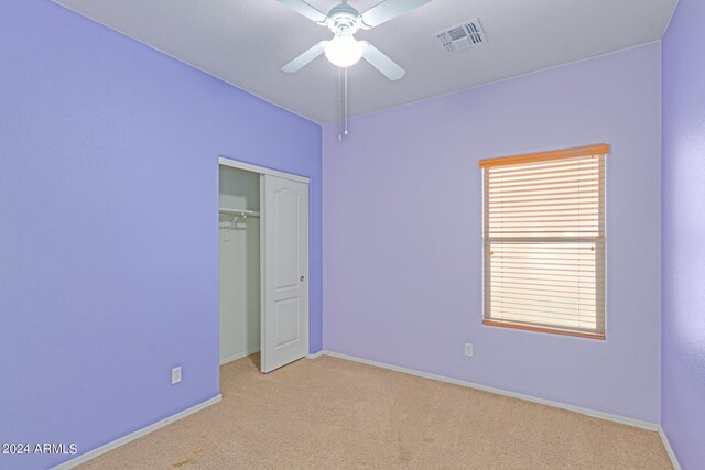 unfurnished room featuring light carpet and ceiling fan