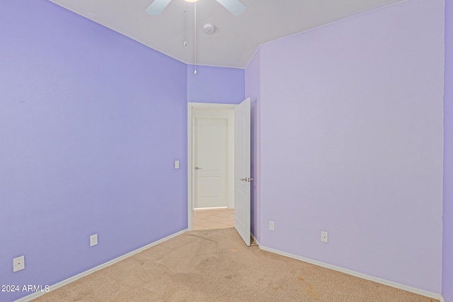 empty room featuring ceiling fan and light colored carpet