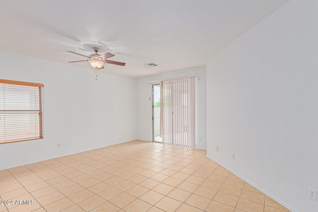 spare room featuring light tile patterned floors and ceiling fan