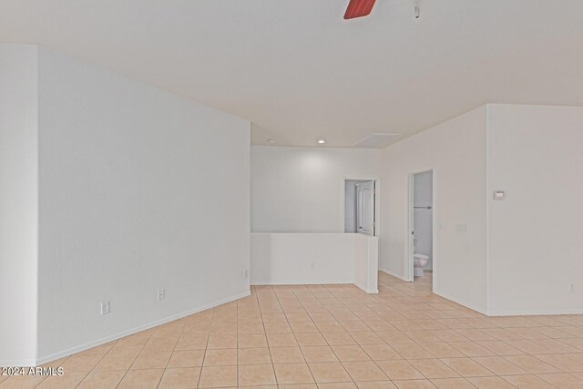 tiled spare room featuring ceiling fan