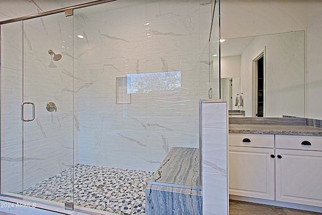 bathroom featuring tile floors, a shower with door, and vanity