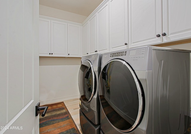 laundry room featuring cabinets, separate washer and dryer, and light hardwood / wood-style floors