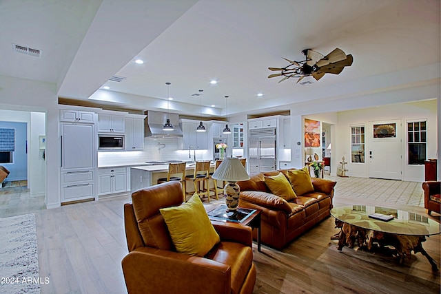 living room featuring ceiling fan and light wood-type flooring