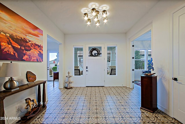 tiled foyer featuring a notable chandelier