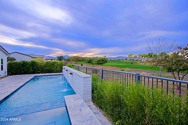 pool at dusk with pool water feature