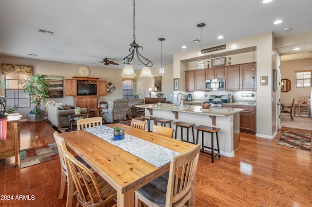 dining space featuring light hardwood / wood-style floors, ceiling fan, and sink