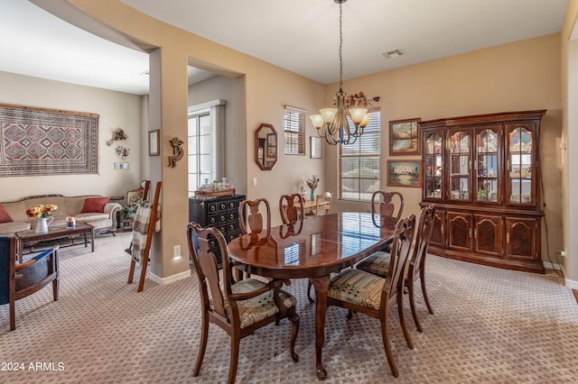 carpeted dining space featuring a chandelier