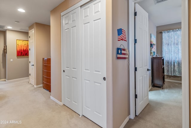 hall with light colored carpet