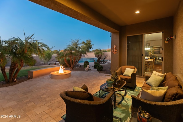 patio terrace at dusk with an outdoor living space with a fire pit