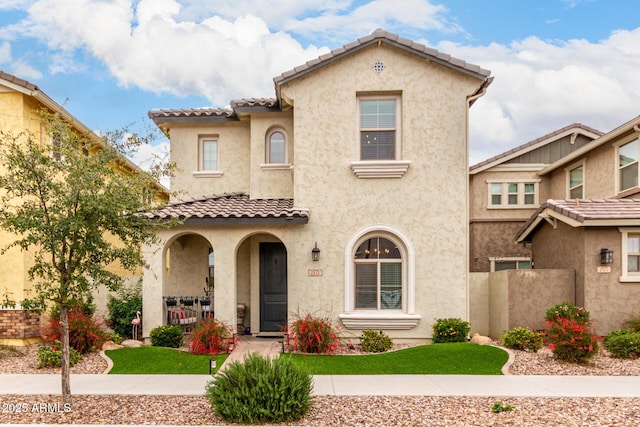 mediterranean / spanish-style home featuring stucco siding, a porch, and a tile roof