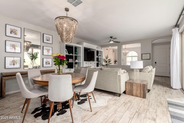 dining room featuring visible vents, ceiling fan with notable chandelier, and light wood-type flooring