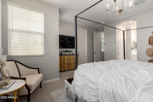 bedroom with ensuite bathroom, a notable chandelier, visible vents, and carpet floors