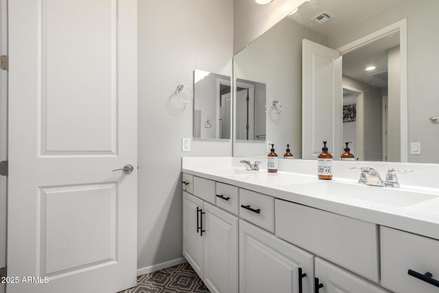 bathroom featuring double vanity, visible vents, baseboards, and a sink