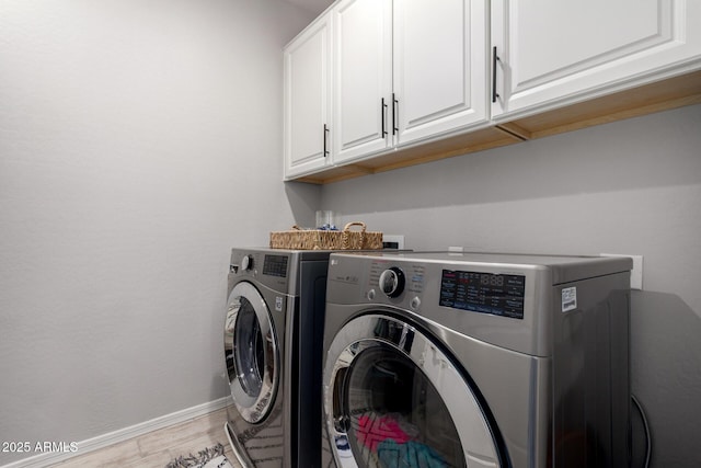 laundry area with cabinet space, independent washer and dryer, baseboards, and light wood-style floors