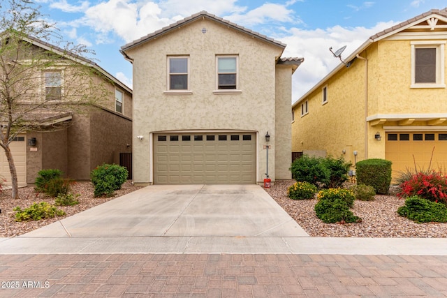 view of front facade with stucco siding, driveway, and an attached garage