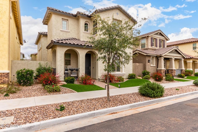 mediterranean / spanish-style home featuring stucco siding, a porch, and a tile roof